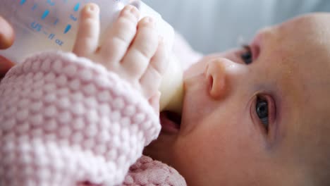 Adorable-baby-girl-being-fed-and-drinking-milk